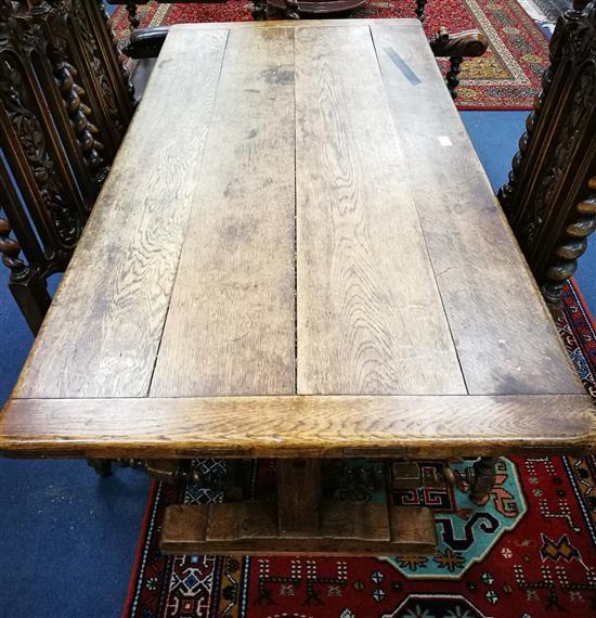 An oak refectory dining table with planked top W.153cm